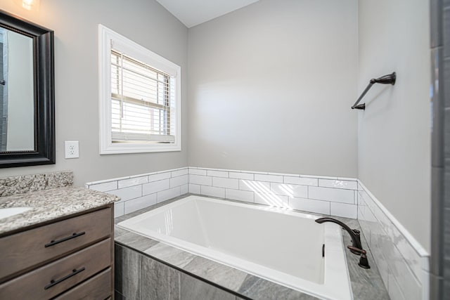 bathroom featuring vanity and a relaxing tiled tub