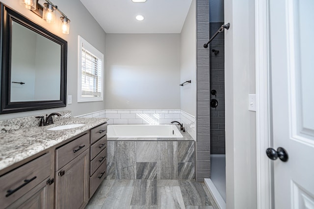 bathroom featuring vanity and shower with separate bathtub