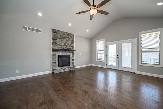 unfurnished living room featuring french doors, vaulted ceiling, dark hardwood / wood-style flooring, ceiling fan, and a fireplace