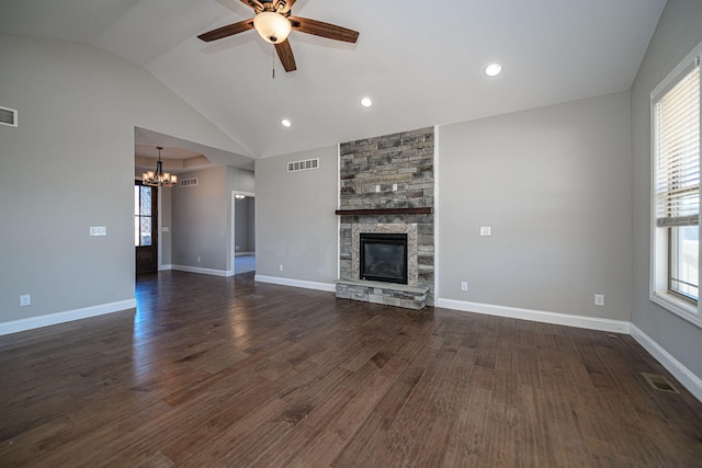 unfurnished living room with vaulted ceiling, a stone fireplace, ceiling fan with notable chandelier, and dark hardwood / wood-style flooring