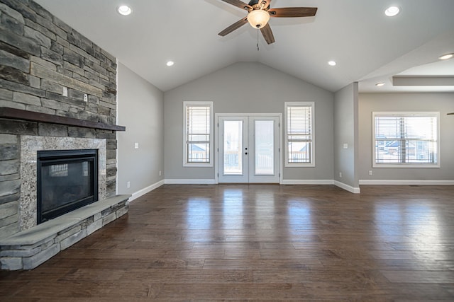 unfurnished living room featuring french doors, lofted ceiling, dark hardwood / wood-style floors, ceiling fan, and a fireplace