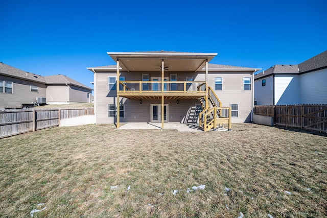 back of house with a wooden deck, ceiling fan, a patio area, and a lawn