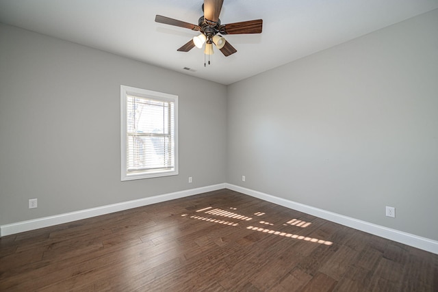 empty room with dark hardwood / wood-style flooring and ceiling fan