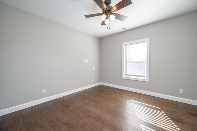 empty room with ceiling fan and dark hardwood / wood-style floors