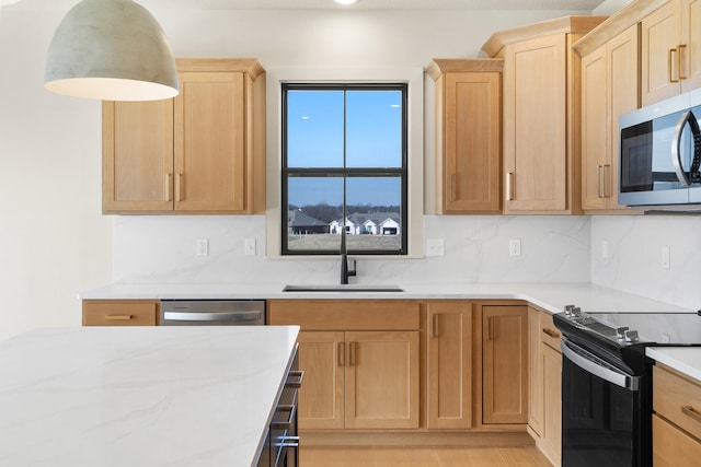 kitchen featuring a sink, stainless steel appliances, tasteful backsplash, and light brown cabinets