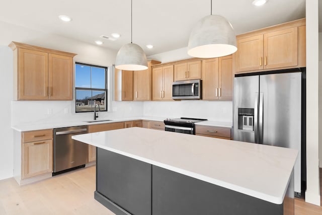 kitchen with light brown cabinetry, appliances with stainless steel finishes, light countertops, and a sink