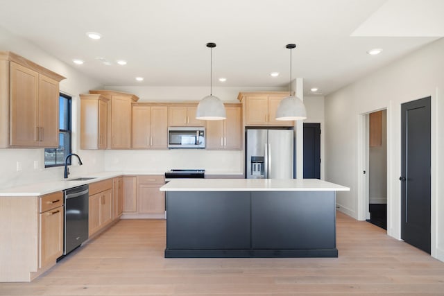 kitchen featuring a sink, a kitchen island, appliances with stainless steel finishes, and light brown cabinets