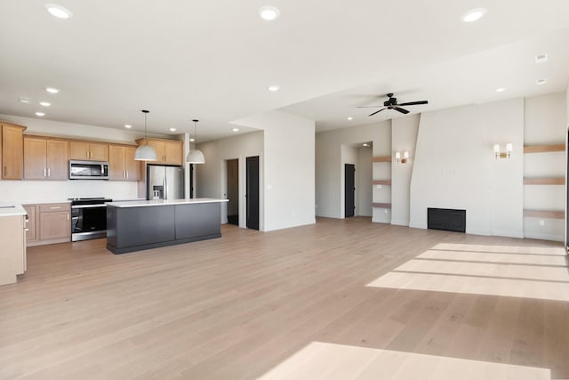 kitchen featuring recessed lighting, stainless steel appliances, light countertops, light wood-style floors, and open floor plan