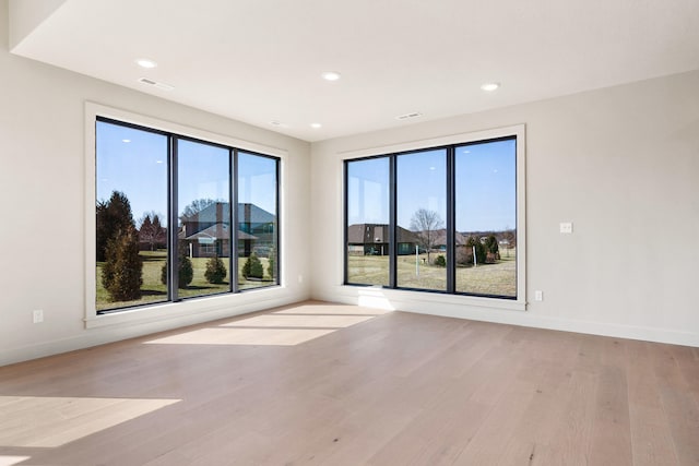 unfurnished room with visible vents, baseboards, and wood finished floors