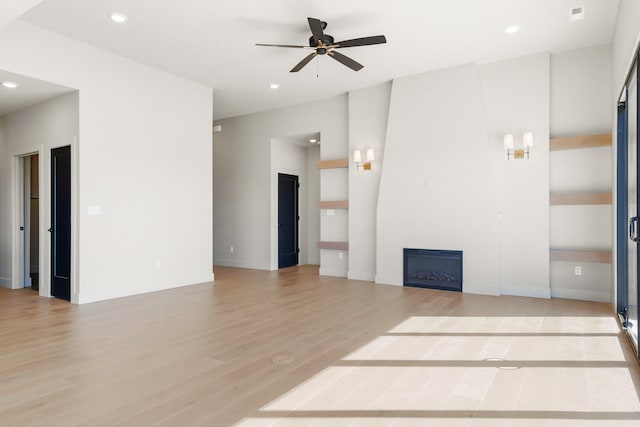 unfurnished living room featuring visible vents, light wood-style flooring, recessed lighting, ceiling fan, and a large fireplace