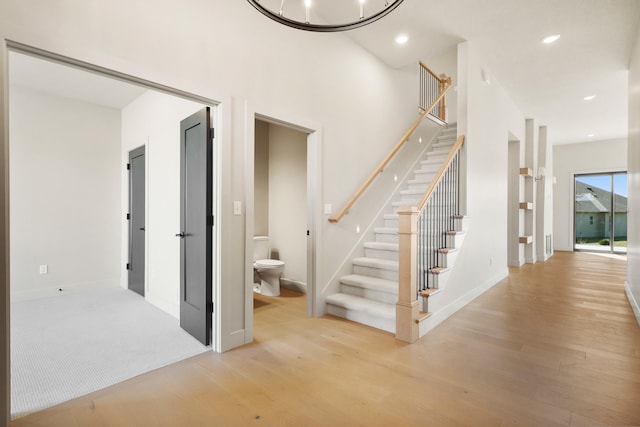 staircase featuring an inviting chandelier, recessed lighting, wood finished floors, and baseboards