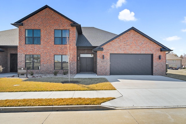 traditional home featuring brick siding, a shingled roof, concrete driveway, a front yard, and a garage