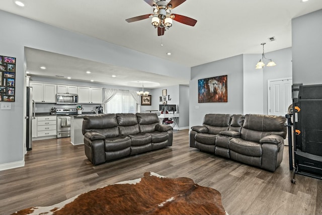 living room featuring ceiling fan with notable chandelier and wood-type flooring