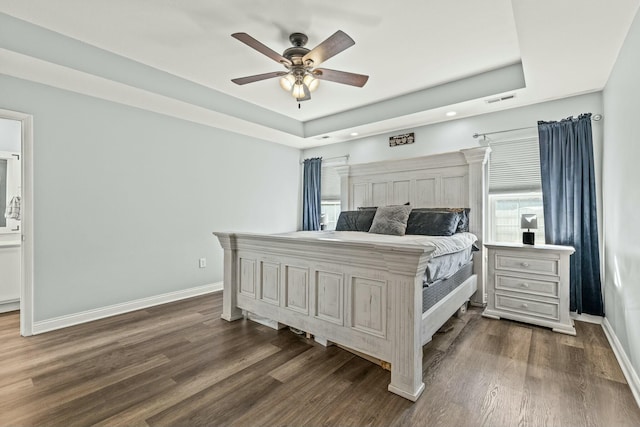 bedroom featuring dark wood-type flooring, ceiling fan, and a tray ceiling