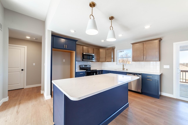 kitchen featuring sink, hanging light fixtures, stainless steel appliances, a center island, and tasteful backsplash