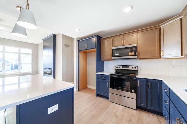 kitchen with pendant lighting, appliances with stainless steel finishes, light hardwood / wood-style floors, blue cabinets, and decorative backsplash