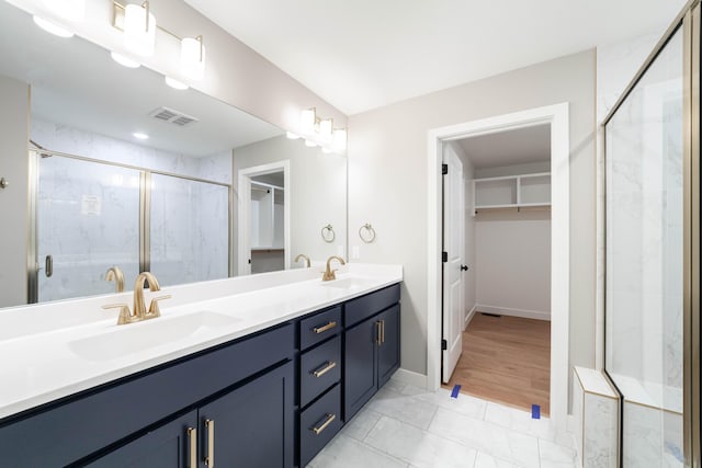 bathroom with vanity and a shower with door