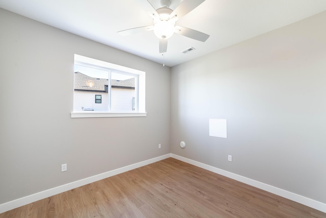 empty room with ceiling fan and light hardwood / wood-style flooring