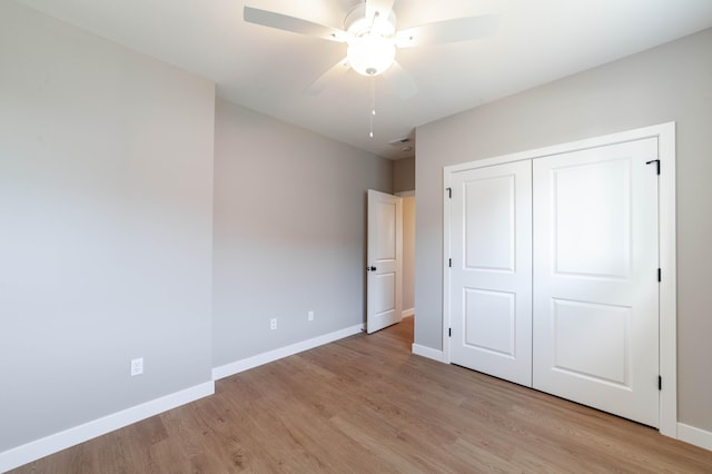 unfurnished bedroom featuring ceiling fan, light hardwood / wood-style floors, and a closet