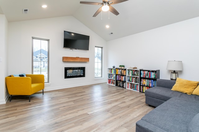 sitting room with ceiling fan, plenty of natural light, high vaulted ceiling, and light hardwood / wood-style floors