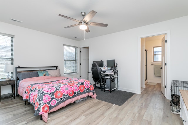 bedroom featuring ceiling fan, multiple windows, and light hardwood / wood-style flooring