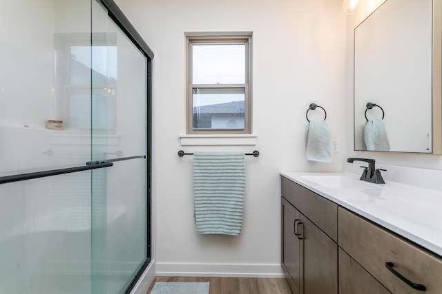 bathroom with hardwood / wood-style flooring, vanity, and walk in shower