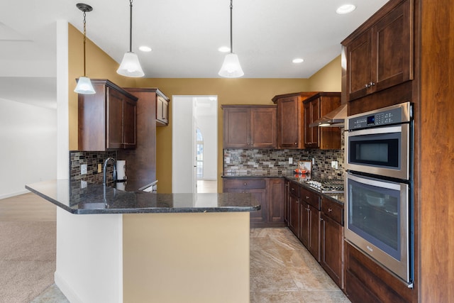 kitchen featuring double oven, hanging light fixtures, dark brown cabinets, and kitchen peninsula