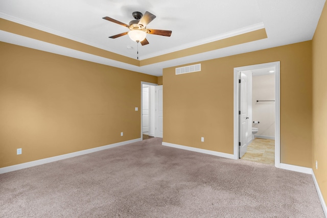 unfurnished room featuring ornamental molding, light colored carpet, a raised ceiling, and ceiling fan