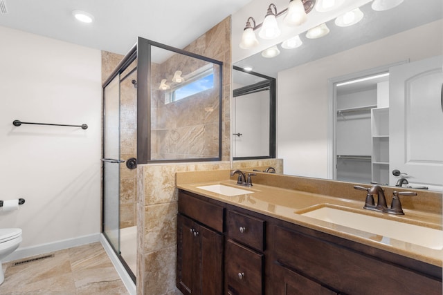 bathroom with an enclosed shower, vanity, and toilet