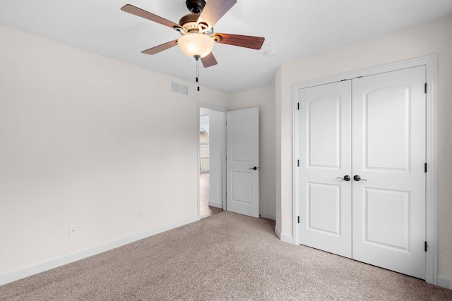 unfurnished bedroom with ceiling fan, a closet, and light carpet