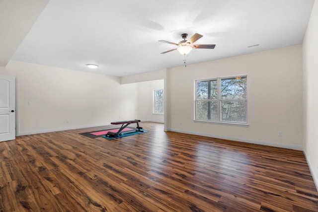 exercise room with ceiling fan and dark hardwood / wood-style flooring