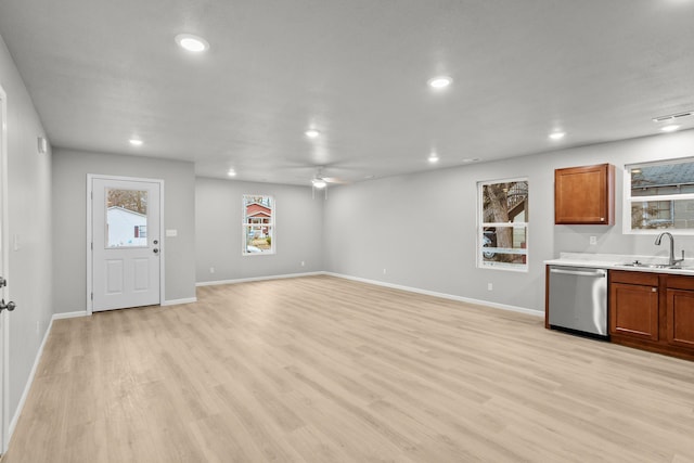 unfurnished living room featuring ceiling fan, sink, and light hardwood / wood-style floors