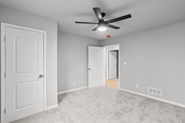 unfurnished bedroom with light colored carpet and ceiling fan