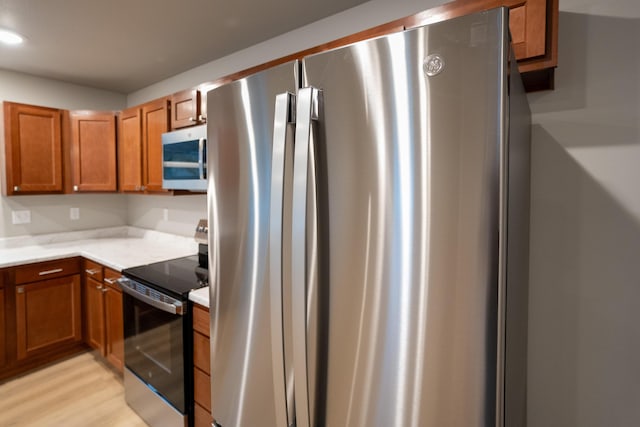 kitchen featuring stainless steel appliances and light hardwood / wood-style floors