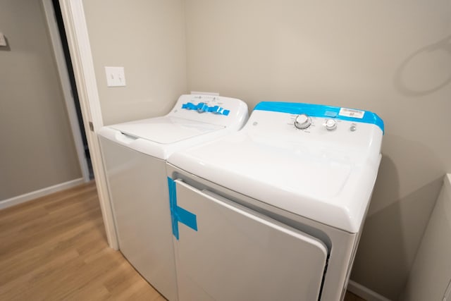 washroom with independent washer and dryer and light hardwood / wood-style flooring