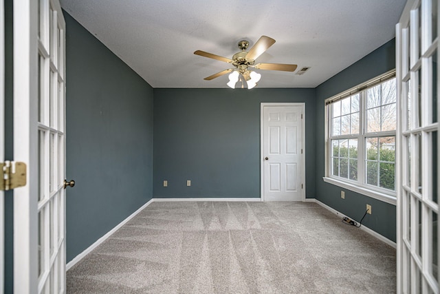 unfurnished room with carpet floors, ceiling fan, and french doors