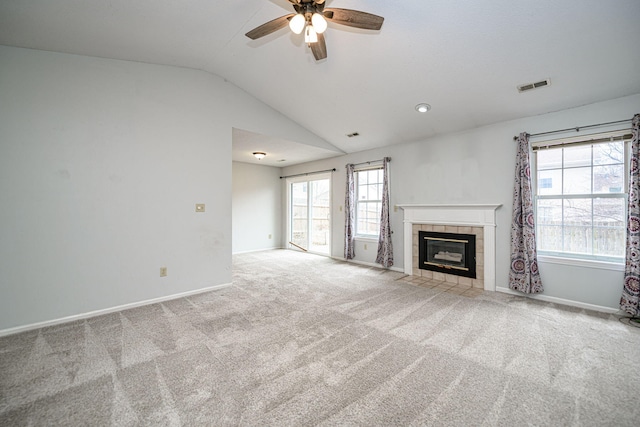 unfurnished living room with lofted ceiling, a fireplace, light colored carpet, and ceiling fan