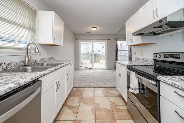 kitchen with stainless steel appliances, white cabinetry, sink, and light stone counters