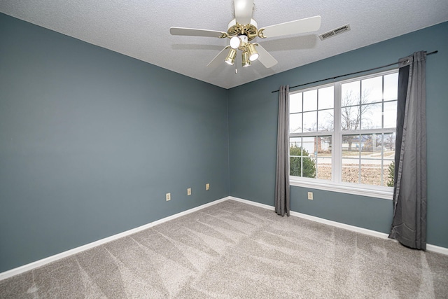 spare room featuring ceiling fan, carpet floors, and a textured ceiling