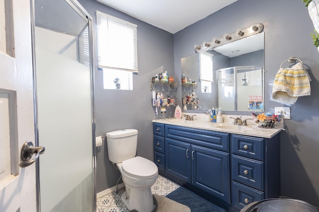 bathroom featuring vanity, a wealth of natural light, a shower with door, and toilet