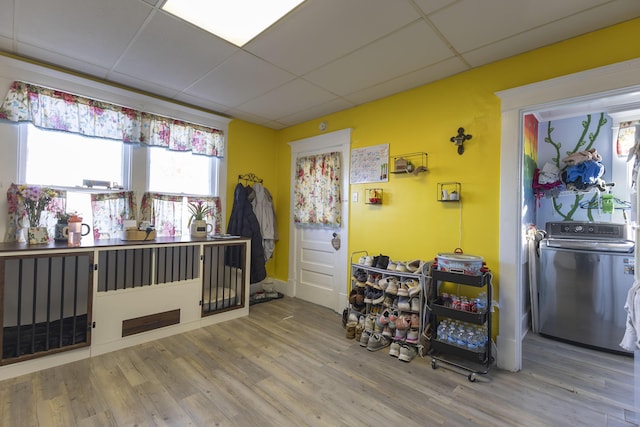 bedroom with washer / clothes dryer, a paneled ceiling, and hardwood / wood-style floors