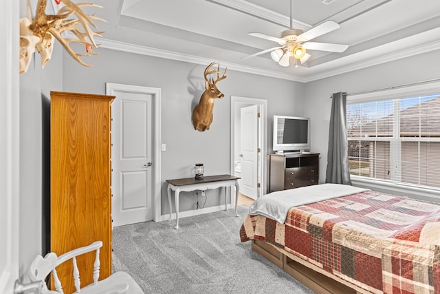 bedroom featuring light carpet, crown molding, a tray ceiling, and ceiling fan