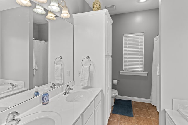 bathroom featuring vanity, tile patterned floors, and toilet