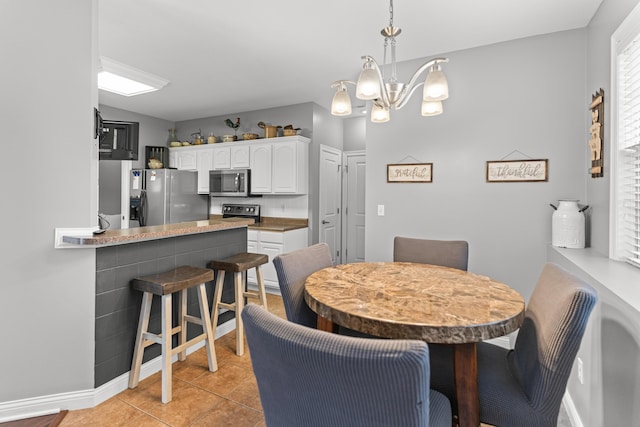 tiled dining area with a chandelier