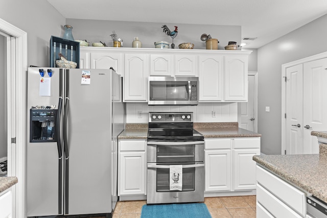 kitchen with white cabinetry, appliances with stainless steel finishes, tasteful backsplash, and light tile patterned floors