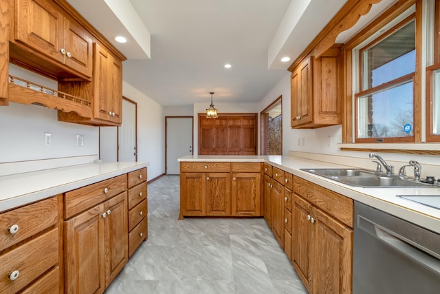 kitchen featuring dishwasher, a peninsula, brown cabinetry, and light countertops