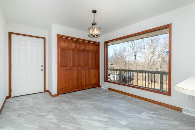 unfurnished bedroom with a chandelier, visible vents, baseboards, and a closet