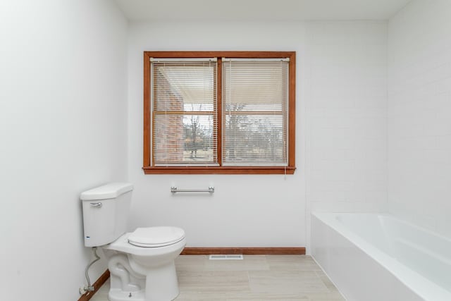 bathroom with visible vents, baseboards, walk in shower, toilet, and a bathtub