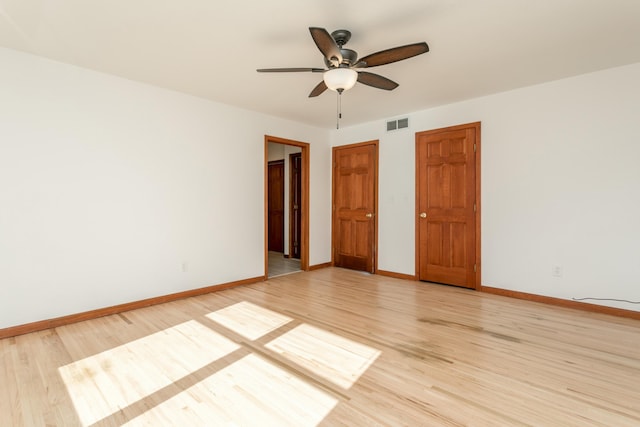 spare room with ceiling fan, visible vents, baseboards, and light wood-style flooring