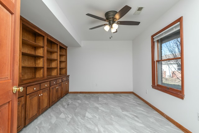 interior space with visible vents, baseboards, and ceiling fan